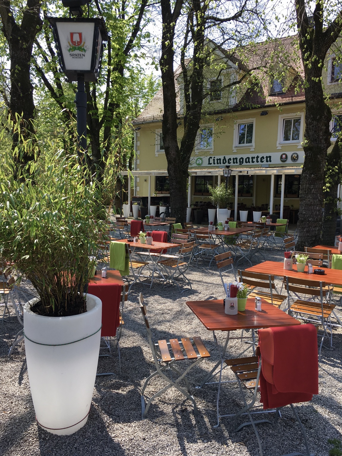 Biergarten unter alten Linden mit Blick auf das Wirtshaus