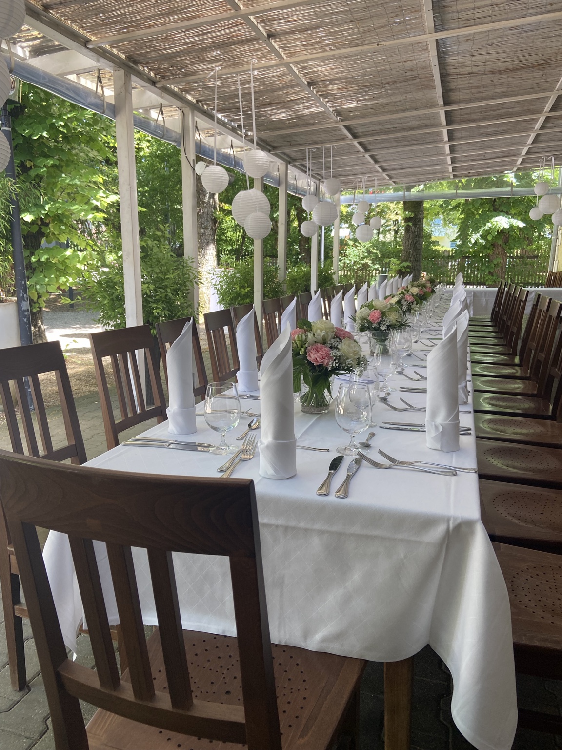 Lange festlich gedeckte Tafel auf der Terrasse